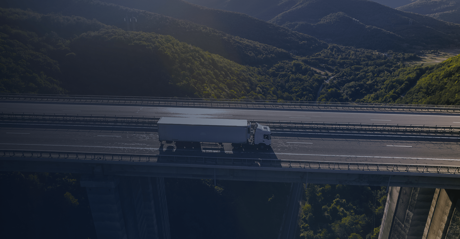 Caminhão percorrendo uma rodovia elevada entre montanhas